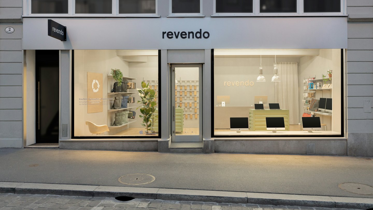 Modern storefront with electronics and plants in the window.