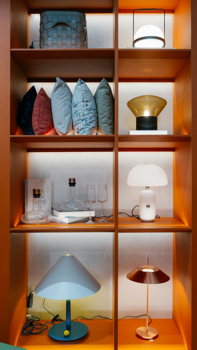 Modern home decor products arranged on illuminated wooden shelves.